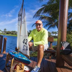 man with remote controlled sailboat